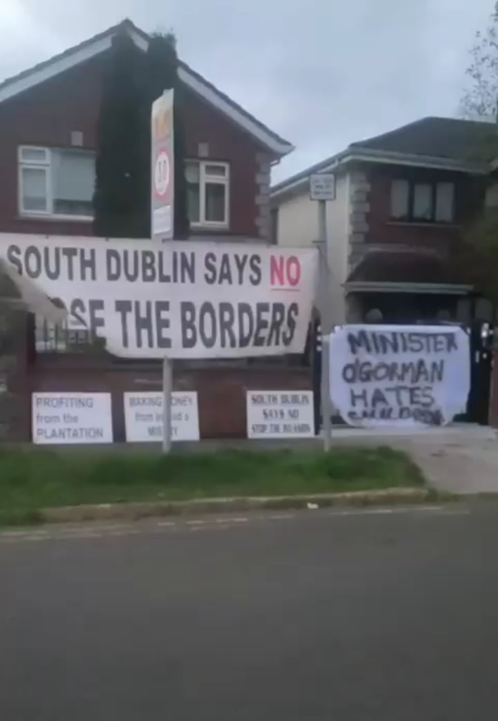 Masked men hang banners on Roderic O'Gormans house while the guards watch and do nothing.