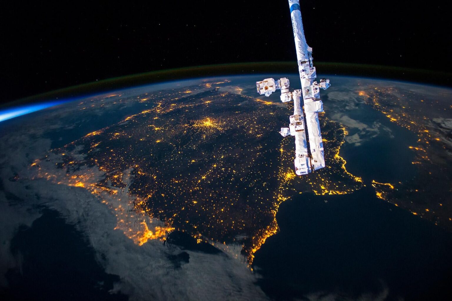 Iberian Peninsula from space, with a sliver of sun in the background