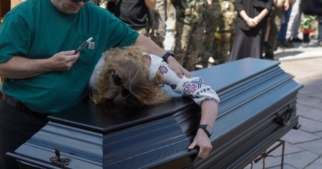 Ukrainian soldiers fall to their knees in last goodbye to Brit killed in battle