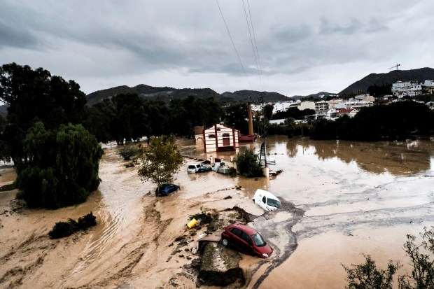 Cars are swept away by the water, after floods preceded by heavy rains caused the river to overflow its banks in the town of Alora, Malaga, Spain, Tuesday, Oct. 29, 2024. (AP Photo/Gregorio Marrero)