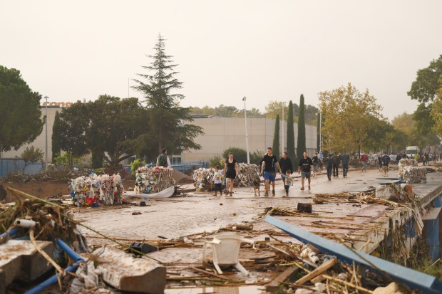 VALENCIA, SPAIN - OCTOBER 30: People walk through debris-covered streets after flash flooding hit the region overnight on October 30, 2024 in Valencia, Spain. Spanish authorities said on Wednesday that at least 51 people had died in the Valencia region overnight after flash-flooding followed heavy rain. Spain's meteorological agency had issued its highest alert for the region due to extreme rainfall. (Photo by David Ramos/Getty Images)