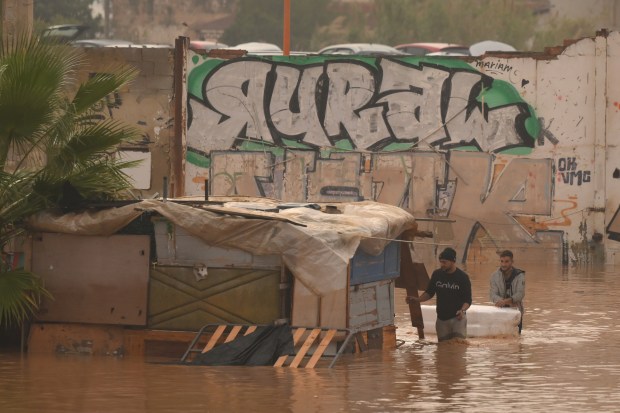 VALENCIA, SPAIN - OCTOBER 30: People wade through flood waters after heavy rain hit the region on October 30, 2024 in Valencia, Spain. Spanish authorities said on Wednesday that at least 51 people had died in the Valencia region overnight after flash-flooding followed heavy rain. Spain's meteorological agency had issued its highest alert for the region due to extreme rainfall. (Photo by David Ramos/Getty Images)
