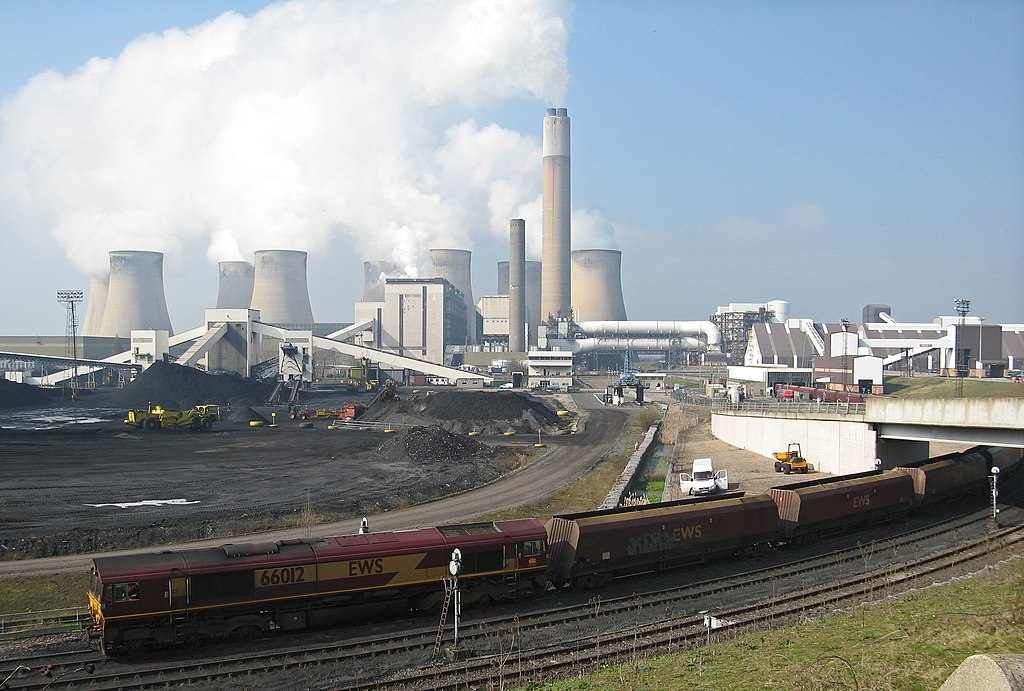 Ratcliffe-on-Soar power station, from the east, with a train of coal being unloaded as it passes at walking pace through the building at middle right.