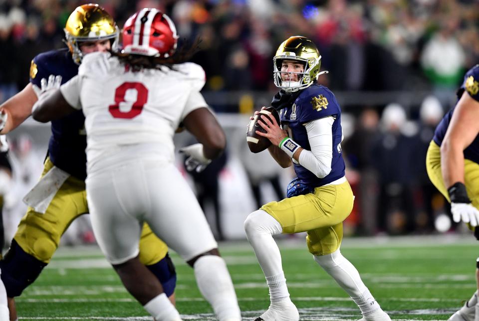 Dec 20, 2024; Notre Dame, Indiana, USA; Notre Dame Fighting Irish quarterback Riley Leonard (13) drops to throw during the first quarter against the Indiana Hoosiers at Notre Dame Stadium. Mandatory Credit: Matt Cashore-Imagn Images