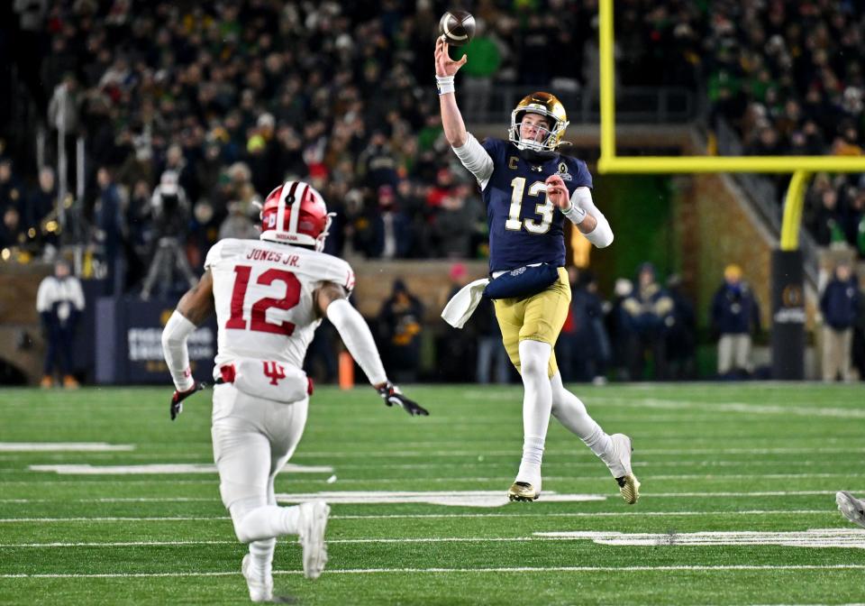 Dec 20, 2024; Notre Dame, Indiana, USA; Notre Dame Fighting Irish quarterback Riley Leonard (13) throws against Indiana Hoosiers defensive back Terry Jones Jr. (12) during the third quarter at Notre Dame Stadium. Mandatory Credit: Matt Cashore-Imagn Images