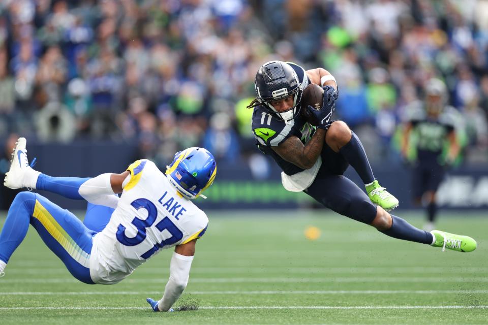 SEATTLE, WASHINGTON - NOVEMBER 03: Jaxon Smith-Njigba #11 of the Seattle Seahawks runs with the ball as Quentin Lake #37 of the Los Angeles Rams looks on during the second quarter at Lumen Field on November 03, 2024 in Seattle, Washington. (Photo by Steph Chambers/Getty Images)