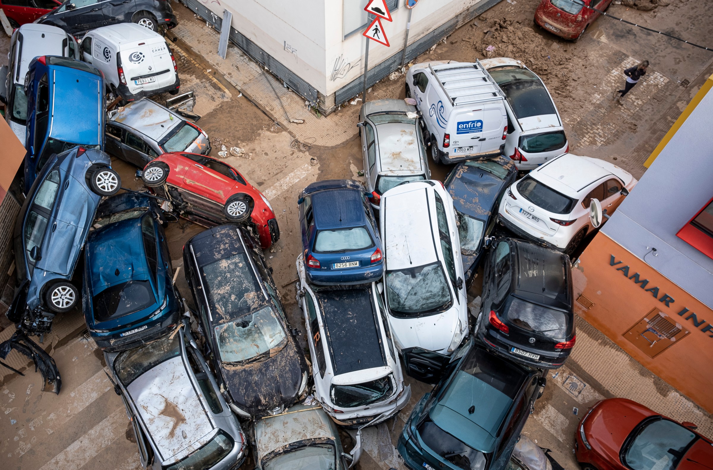 Cars carried by floodwaters, a few on top of another car