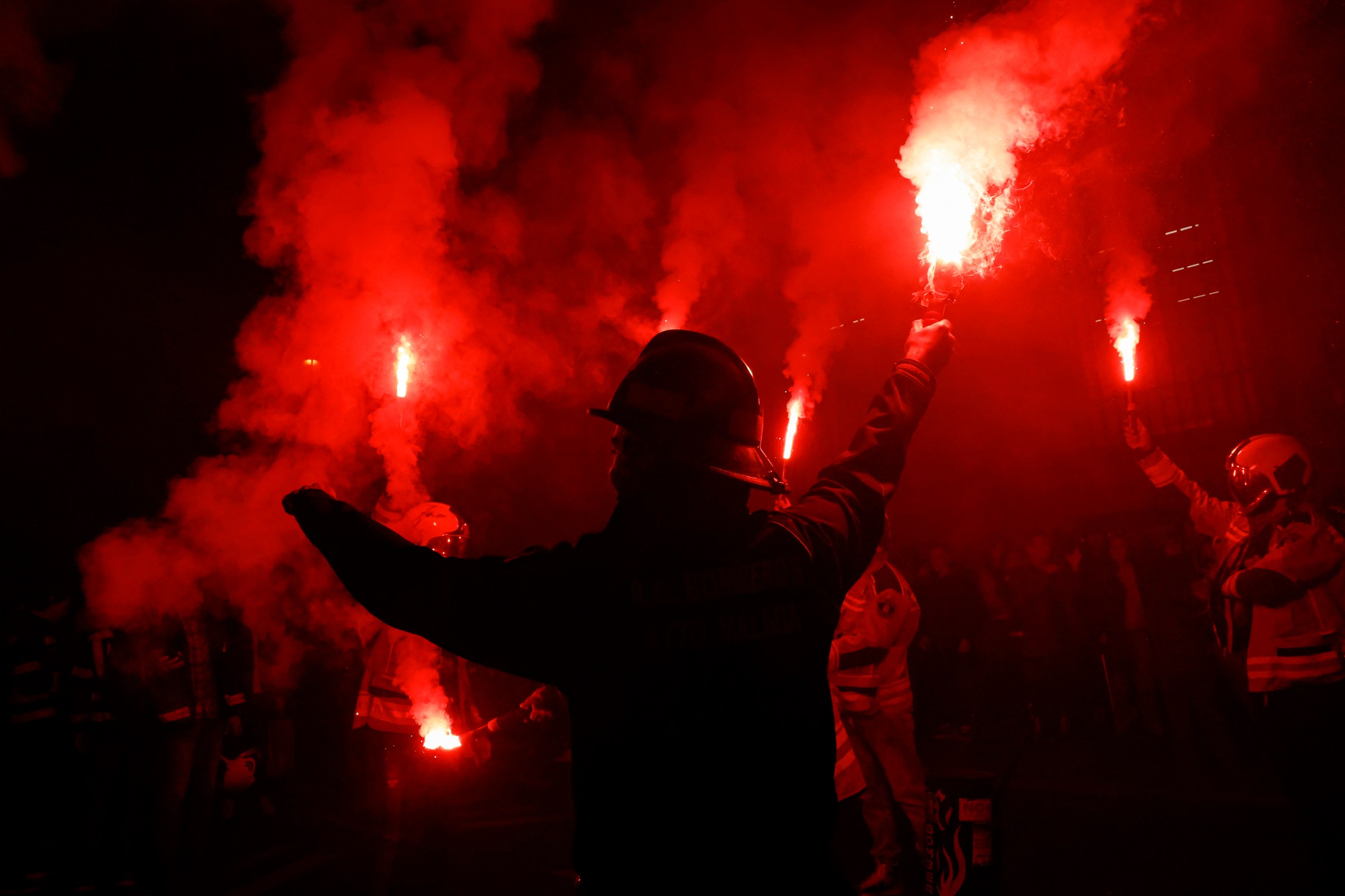 Firefighters light flares during a protest over what they say is a lack of coordination during tragedies such as the latest devastating flooding in the Valencia region, in Madrid on November 30, 2024.