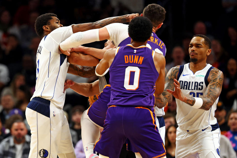 Dec 27, 2024; Phoenix, Arizona, USA; Dallas Mavericks forward Naji Marshall (13) punches Phoenix Suns center Jusuf Nurkic (20) during the third quarter at Footprint Center. Mandatory Credit: Mark J. Rebilas-Imagn Images