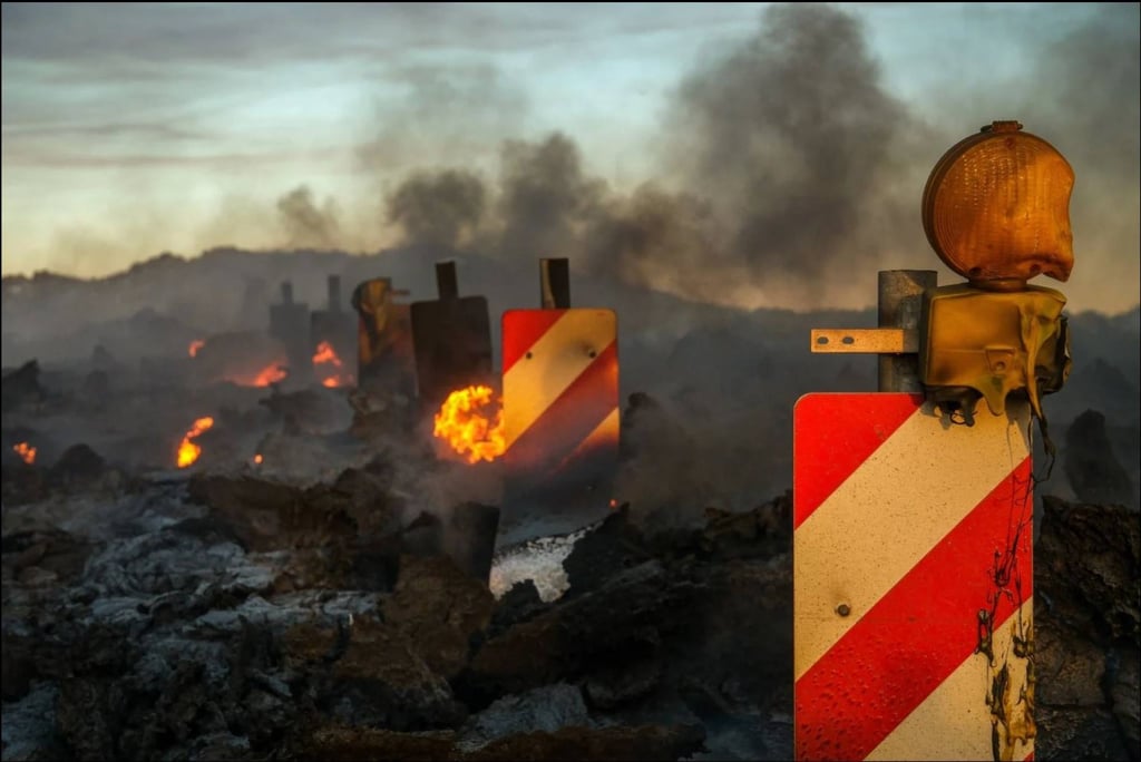 Traffic signs melt as lava flows over a road during a volcanic eruption near Grindavík. Photo: EPA-EFE