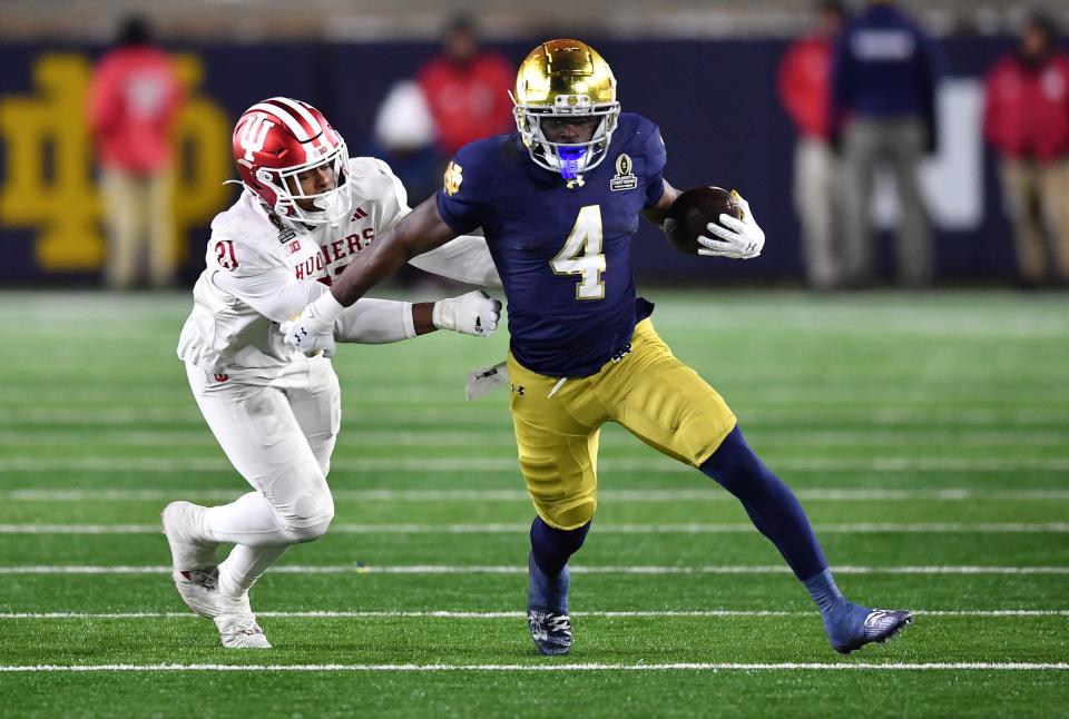 Dec 20, 2024; Notre Dame, Indiana, USA; Notre Dame Fighting Irish running back Jeremiyah Love (4) runs against Indiana Hoosiers linebacker Rolijah Hardy (21) during the third quarter at Notre Dame Stadium. Mandatory Credit: Matt Cashore-Imagn Images