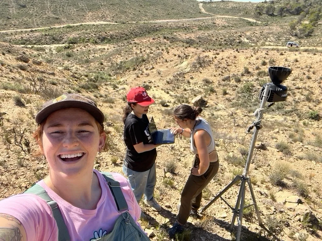 Jill Aire and two colleagues taking field readings in a shrub-desert landscape in Spain.