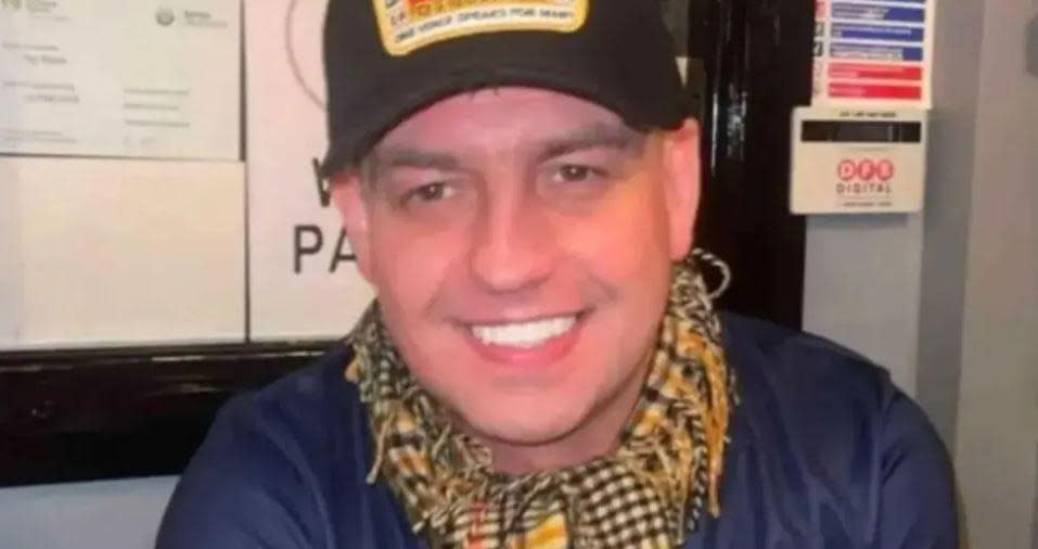 John George seen in a blue T-shirt, scarf and hat.