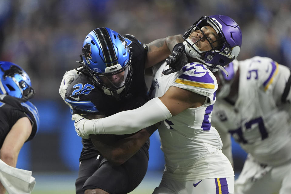 Detroit Lions running back Jahmyr Gibbs (26) runs against Minnesota Vikings safety Camryn Bynum (24) for a first down during the second half of an NFL football game Sunday, Jan. 5, 2025, in Detroit. (AP Photo/Charlie Riedel)