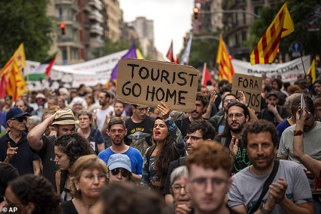 Demonstrators march shouting slogans against the Formula 1 Barcelona Fan Festival in downtown Barcelona, Spain, Wednesday, June 19