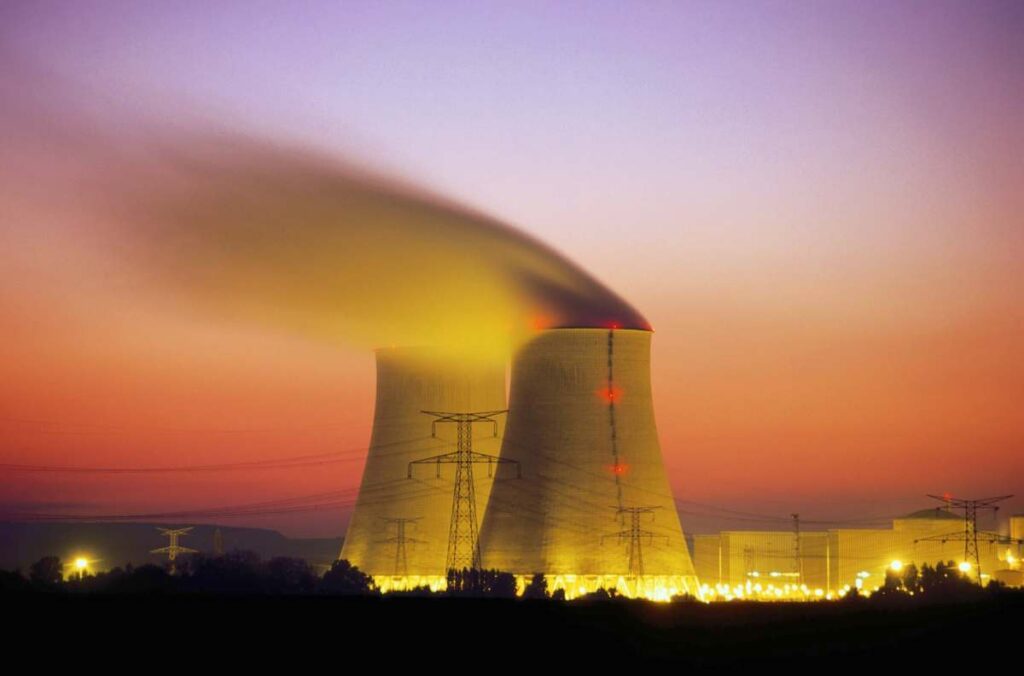 Atomic Canyon wants to be ChatGPT for the nuclear industry Nuclear power plant cooling towers emit steam at dusk.