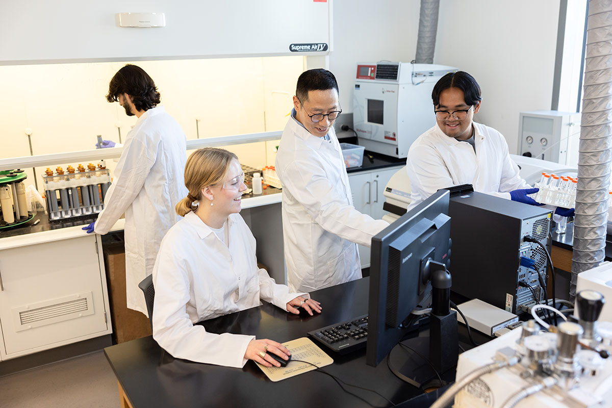 Professor Jin Yong Choi works in chemistry lab with students.