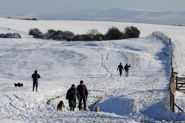 FALMER, UNITED KINGDOM - JANUARY 09: Walkers enjoy the snow at Ditchling Beacon on January 09, 2025 in Ditchling, United Kingdom. The Met Office has issued weather warnings as a cold snap sweeps across the UK, bringing freezing temperatures and bouts of ice, snow, and rain. (Photo by Dan Kitwood/Getty Images)
