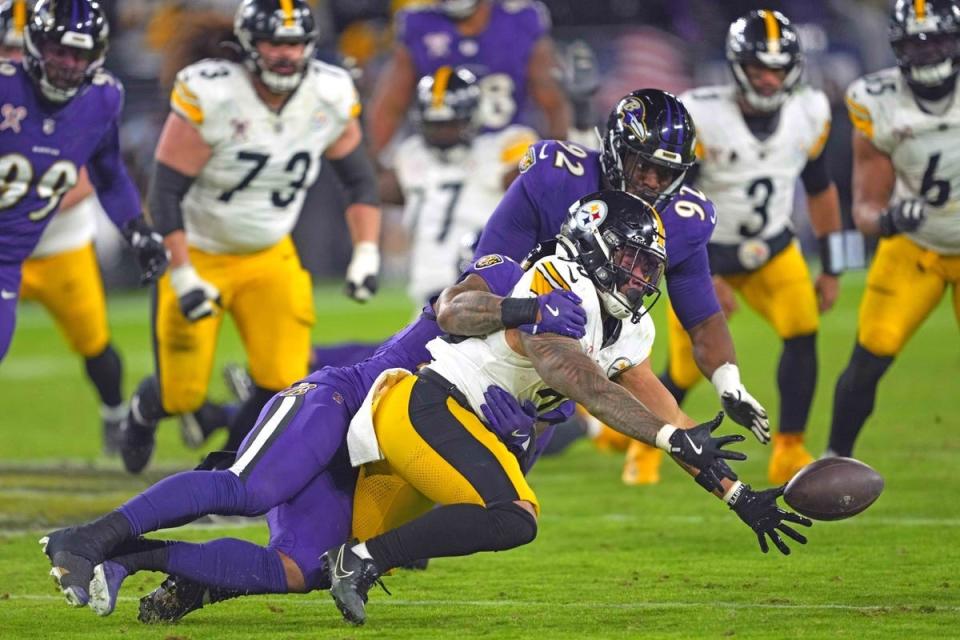 Dec 21, 2024; Baltimore, Maryland, USA; Pittsburgh Steelers running back Jaylen Warren (30) cannot complete the pass during the third quarter defended by Baltimore Ravens lineman Nnamdi Madubuike (92) at M&T Bank Stadium. Mandatory Credit: Mitch Stringer-Imagn Images