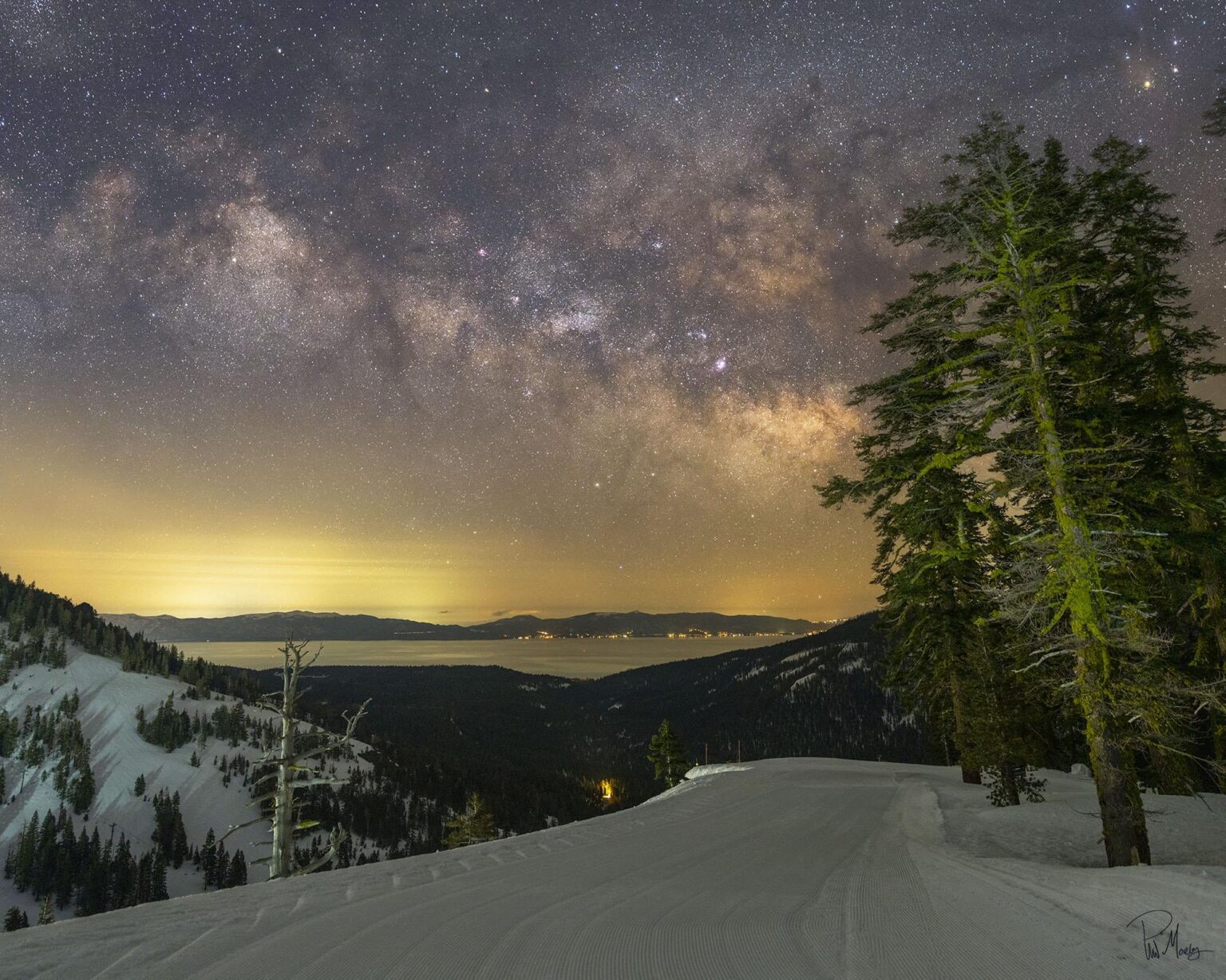 The Milky Way rising over Lake Tahoe from high up in the Alpine Meadows / Palisades ski resort boundary. Foreground light is from snowcats grooming the slopes far behind me.