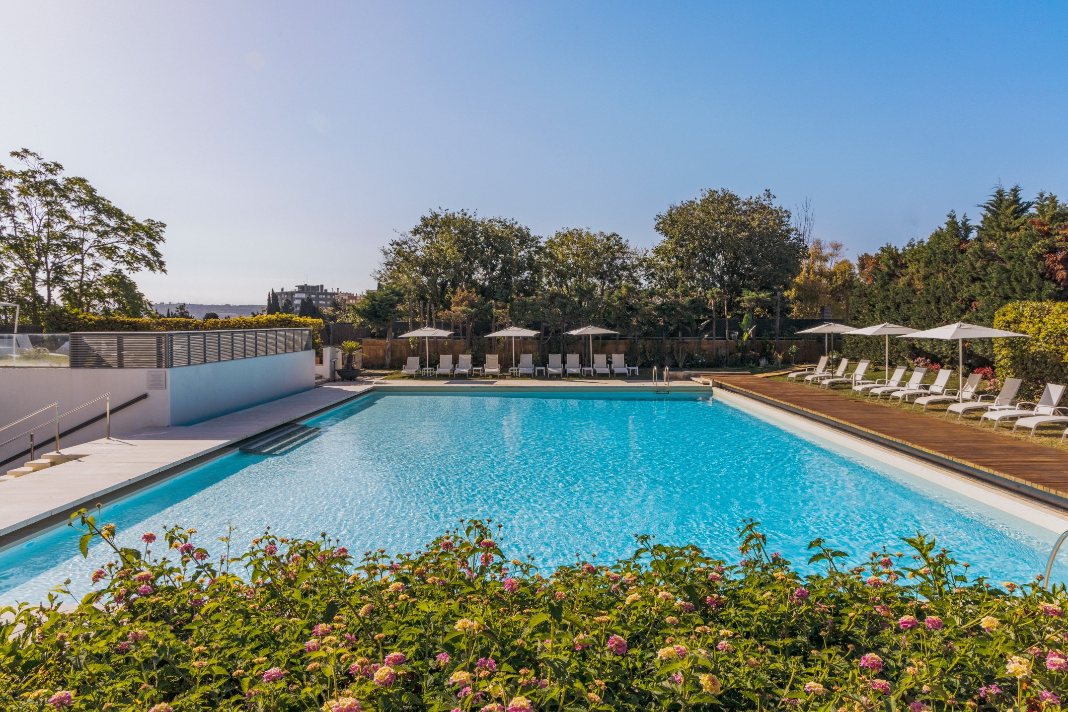 Outdoor pool with lounge chairs and umbrellas.
