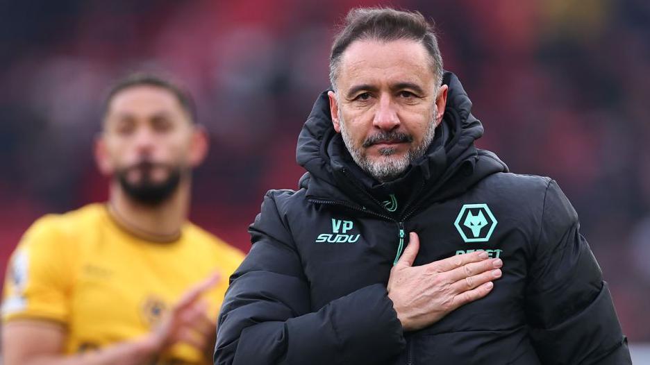 Wolves manager Vitor Pereira with his right hand on the Wolves badge on his coat