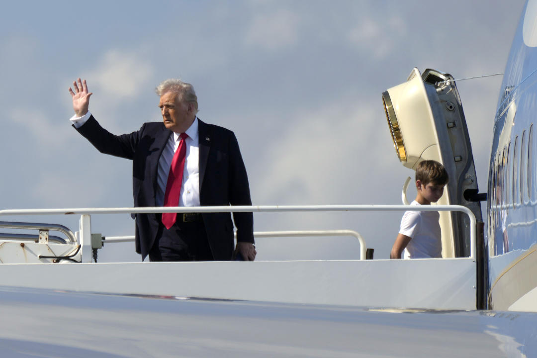 President Donald Trump, left, waves as he boards Air Force One with grandson Theodore, Ivanka Trump's son, at Palm Beach International Airport in West Palm Beach, Fla., Sunday, Feb. 9, 2025. (AP Photo/Ben Curtis)