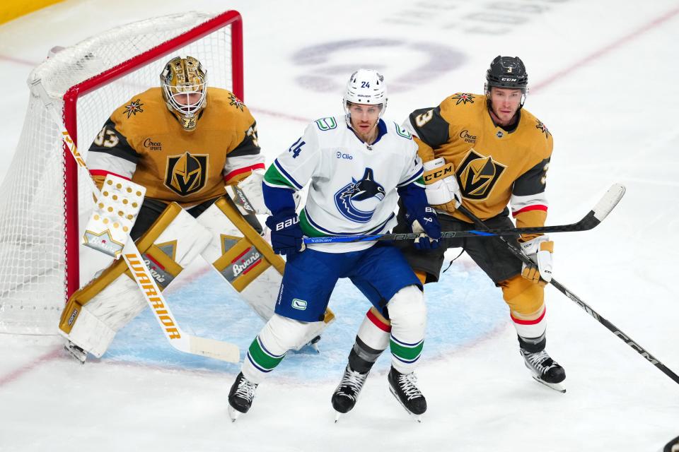 Dec 19, 2024; Las Vegas, Nevada, USA; Vegas Golden Knights goaltender Adin Hill (33) defends his net behind Vancouver Canucks center Pius Suter (24) and Vegas Golden Knights defenseman Brayden McNabb (3) during the third period at T-Mobile Arena. Mandatory Credit: Stephen R. Sylvanie-Imagn Images