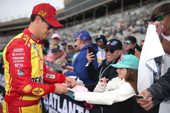 HAMPTON, GEORGIA - FEBRUARY 23: Joey Logano, driver of the #22 Shell Pennzoil Ford, signs an autograph for a young NASCAR fan prior to the NASCAR Cup Series Ambetter Health 400 at Atlanta Motor Speedway on February 23, 2025 in Hampton, Georgia. (Photo by Jonathan Bachman/Getty Images)