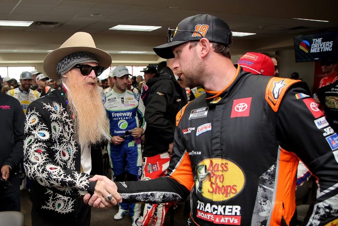 HAMPTON, GEORGIA - FEBRUARY 23: Billy F. Gibbons of ZZ Top is greeted by Chase Briscoe, driver of the #19 Bass Pro Shops Toyota, during the Drivers Meeting prior to the NASCAR Cup Series Ambetter Health 400 at Atlanta Motor Speedway on February 23, 2025 in Hampton, Georgia. (Photo by Jonathan Bachman/Getty Images)