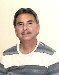 Herman Santaella, retired materials and stores supervisor, wearing a striped shirt.