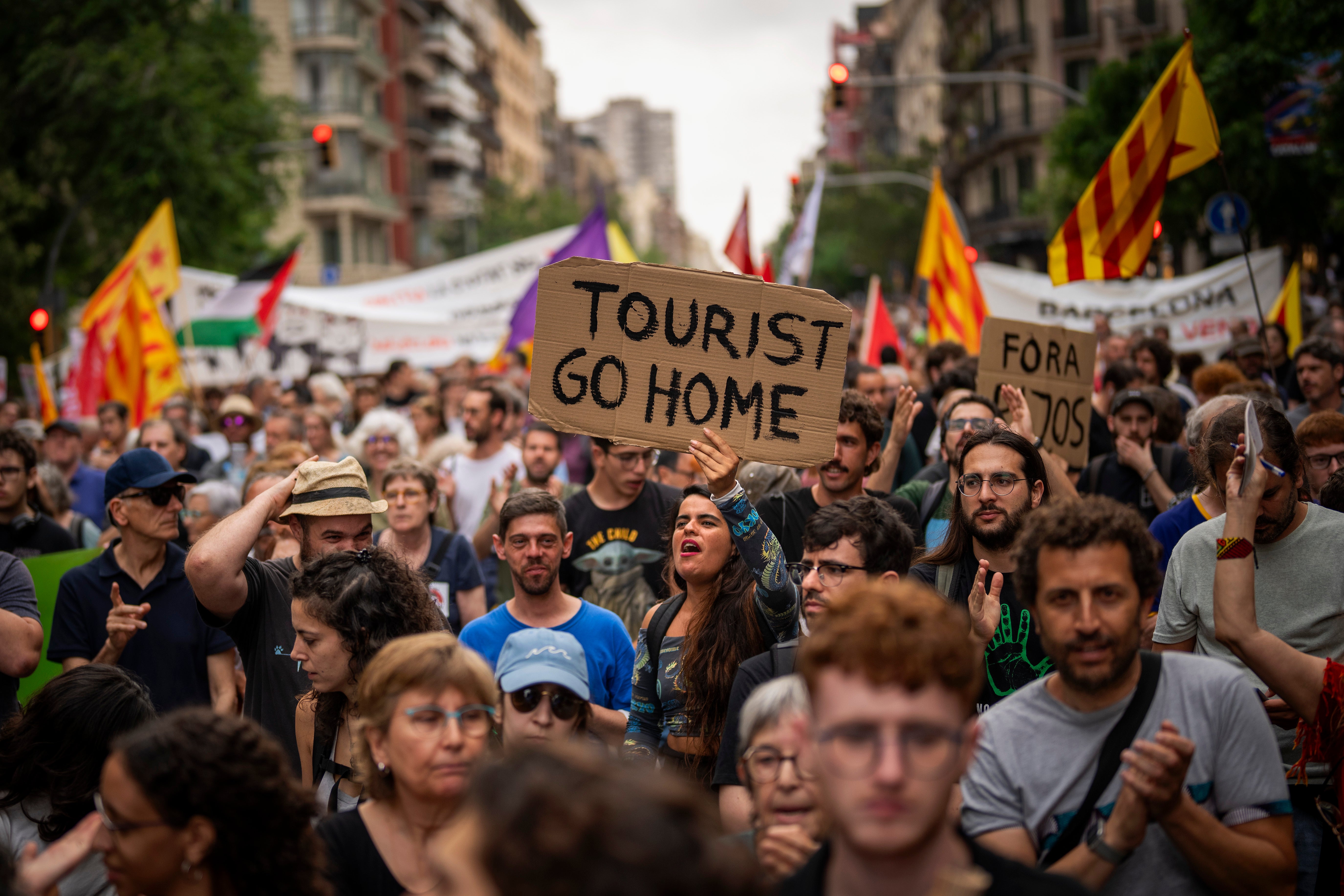 Demonstrators march shouting slogans against the Formula 1 Barcelona Fan Festival in downtown Barcelona, Spain, Wednesday, June 19, 2024, during residents protest against mass tourism