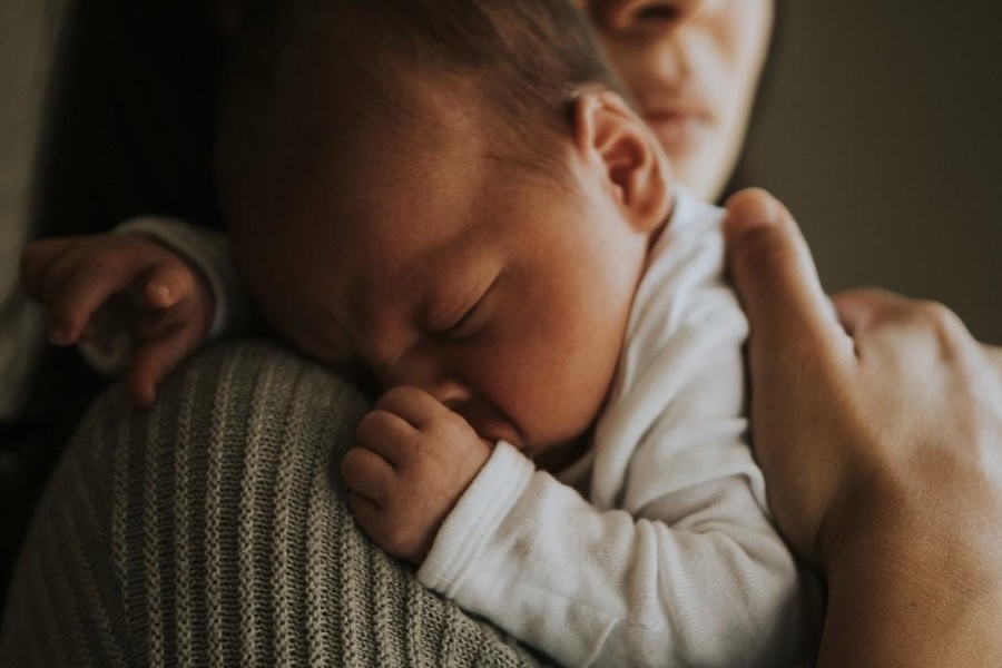 Baby sleeping on mother's shoulder