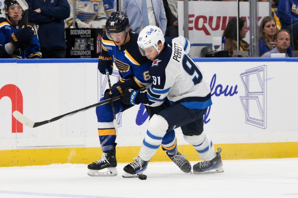 St. Louis Blues forward Dylan Holloway (left) and Winnipeg Jets forward Cole Perfetti battle for a loose puck earlier this season. (Jeff Le-Imagn Images)