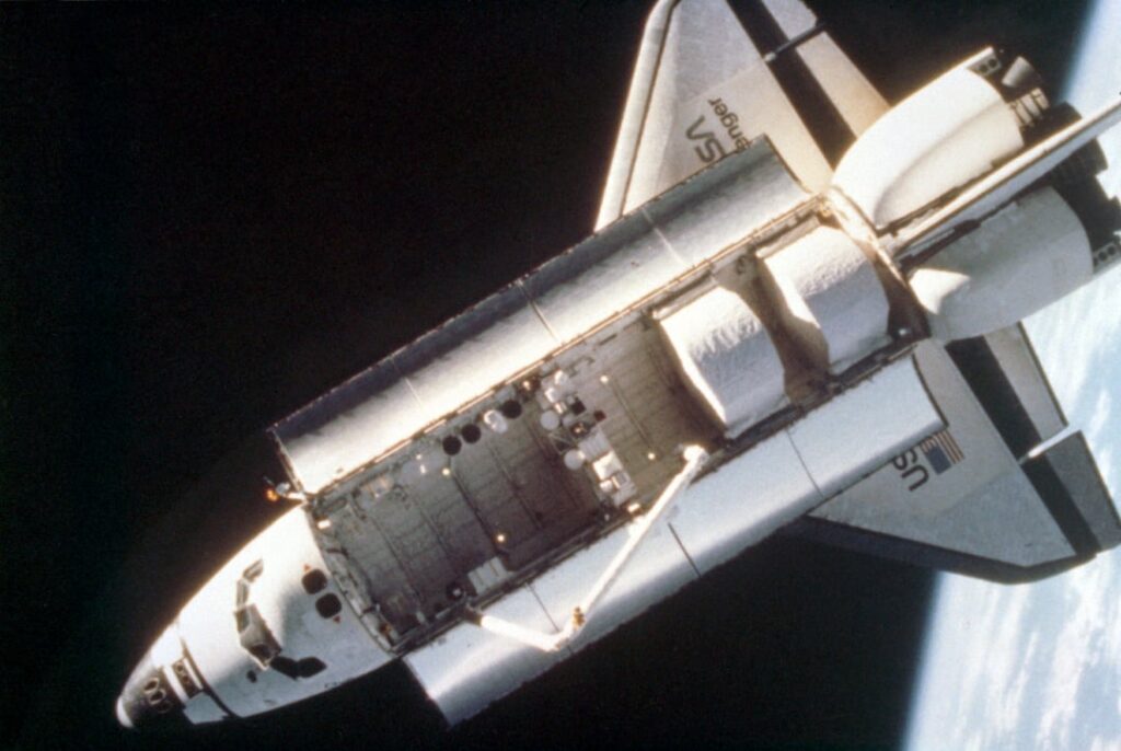 An overhead view of the space shuttle Challenger taken by a fixed camera mounted on astronaut Bruce McCandless’s helmet during the first extravehicular activity (EVA) using the nitrogen-propelled, hand-controlled, manned maneuvering unit (MMU). February 1984 An overhead view of the space shuttle Challenger taken by a fixed camera mounted on astronaut Bruce McCandless's helmet during the first extravehicular activity (EVA) using the nitrogen-propelled, hand-controlled, manned maneuvering unit (MMU). February 1984