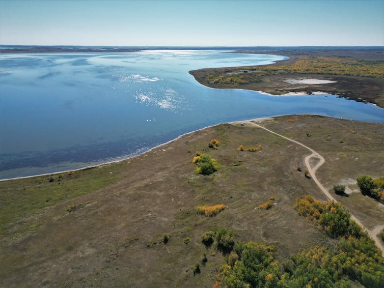 a birds-eye view of a large lake surrounded by flat, dry land