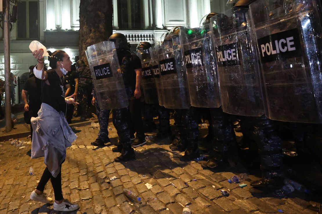 A woman stares down a wall of riot police in Tbilisi, April 30, 2024.
