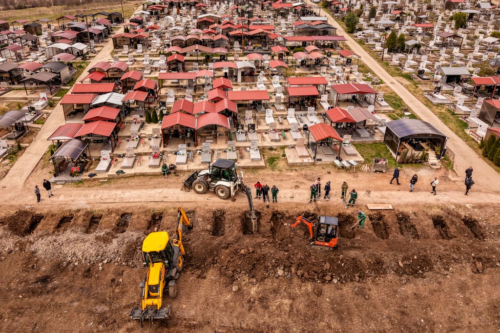 Excavators dig graves on Tuesday for the victims of a nightclub fire in North Macedonia. Photo: AP