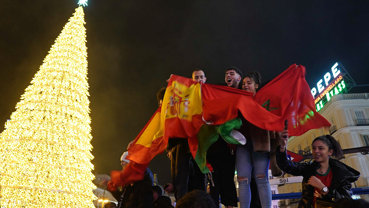 Marroquíes celebran con banderas españolas y marroquíes en la céntrica Puerta del Sol de Madrid, España, el martes 6 de diciembre de 2022 - AP/ ANDREA COMAS