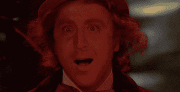 Person wearing a top hat and suit, appearing surprised or delighted, likely from a scene in a movie