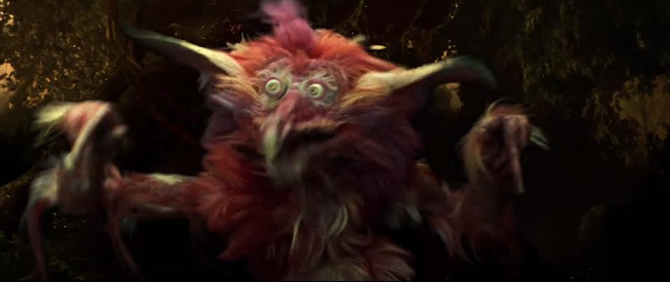 A fuzzy, wild-eyed creature with long ears and fur, looking surprised in a forest setting, featured in a TV or movie scene