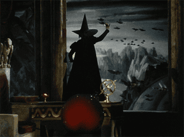 A figure in a witch's outfit, including a tall hat, stands inside, gesturing toward a dark, stormy landscape with flying creatures