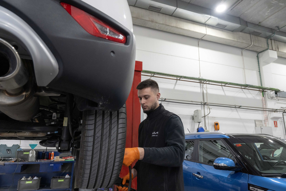 Mechanics examine Kia cars at Kia Integral Car, a dealership in Barcelona, Spain. [KIA]