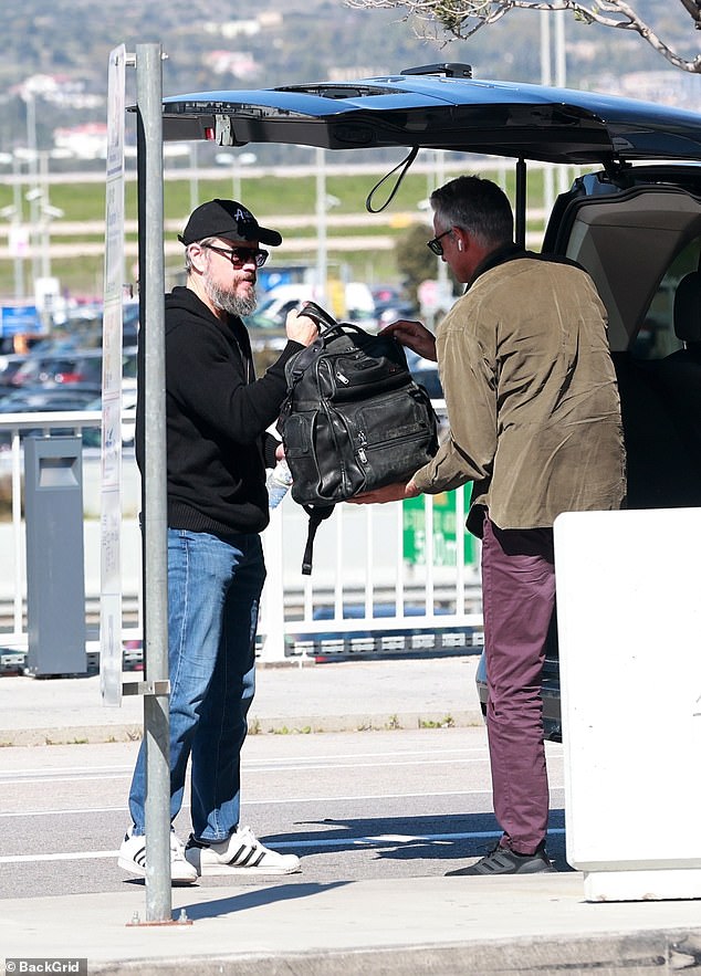 Matt was spotted carrying a large backpack through the airport before stopping and sipping on a bottle of water