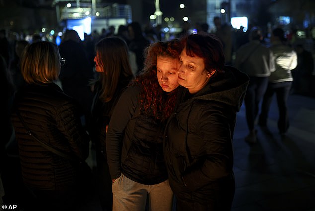 People comfort one another in the aftermath of the tragedy, which claimed at 59 lives