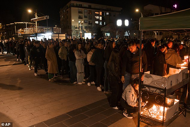 People wait in lines to light candles in memory of the victims, while also praying for the scores of partygoers who have been injured