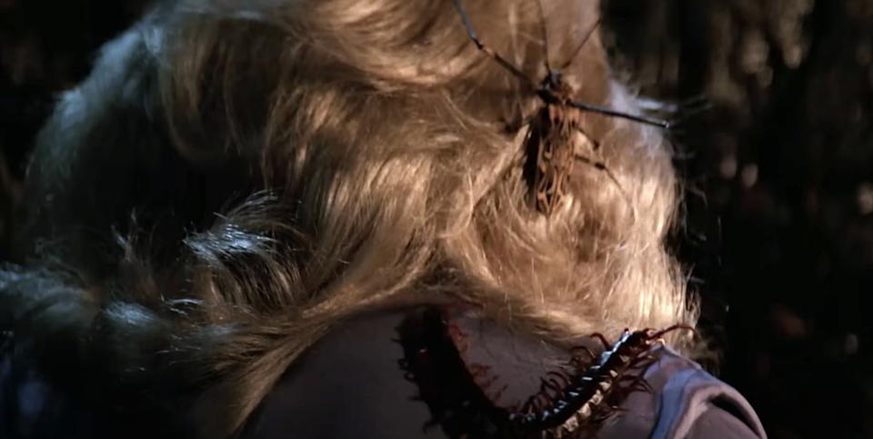 A creepy crawly insect climbs on a person's back, tangled in their blonde hair, creating a tense and eerie moment