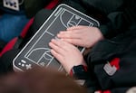 Hank Vogel places his hands on a OneCourt tactile device during a Portland Trail Blazers game, Portland, Ore., Feb. 22, 2025. The device vibrates and offers audio narration so users like Vogel, who is blind, can experience the game in real time. 