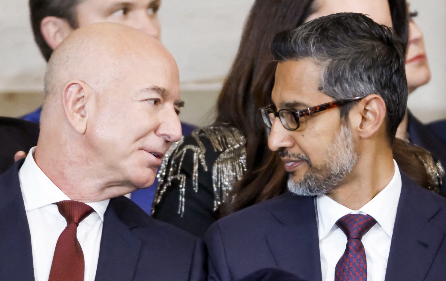Jeff Bezos (L) talks with Alphabet's CEO Sundar Pichai (R) as they attend Donald Trump's inauguration on January 20, 2025.