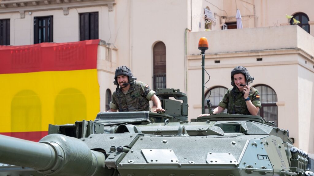 Spain’s Leopard 2 MBTs Getting Major Upgrade Barcelona, Spain; June 1, 2024: Detail of two smiling tank soldiers peeking out of the hatches of the turret of the Leopard tank at the Bruch barracks.